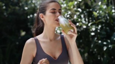 Bahçede detoks suyu içen sağlıklı genç bir kadının videosu.