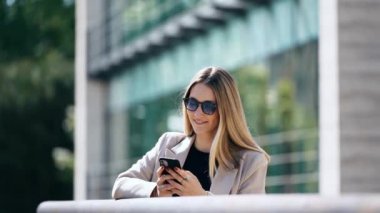 Sokakta yürürken akıllı telefonunu kullanan güzel bir genç kadının videosu.