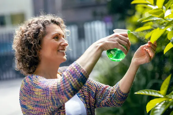 stock image Shot of beautiful smiling woman arranging plants and flowers in a greenhouse