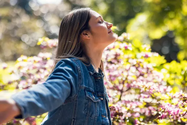 Parkta nefes alıp veren ve meditasyon yapan güzel bir genç kadın..