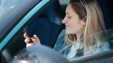 Arabada beklerken akıllı telefon kullanan mutlu bir kadının videosu.
