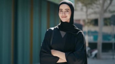 Kendine güvenen, tesettürlü, kentteki kameraya bakan ciddi bir kadının videosu.