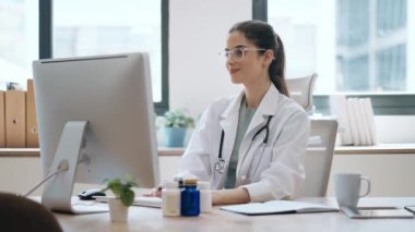 Kadın doktorun hastaya tıbbi tedaviyi bilgisayarla ve kulaklıkla yaptığı bir video ile anlattığı video.