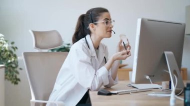 Kadın doktorun hastaya tıbbi tedaviyi bilgisayarla ve kulaklıkla yaptığı bir video ile anlattığı video.