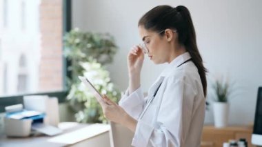 Kadın doktorun muayenede dikilirken dijital tabletini kullanmasının videosu.