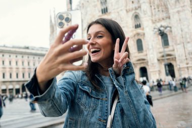 Milan 'ın sokaklarını gezerken akıllı telefonuyla kendi fotoğraflarını çekerken çekilmiş güzel bir fotoğraf.