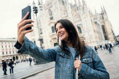 Milan 'ın sokaklarını gezerken akıllı telefonuyla kendi fotoğraflarını çekerken çekilmiş güzel bir fotoğraf.