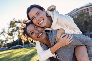 İki güzel kadının parkta kameraya poz verdikten sonra eğlenirken çekilmesi.