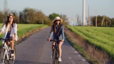 İHA 'lı genç kadın arkadaşlarının yel değirmeni tarlalarında bisiklet sürerken ve konuşurken videosu