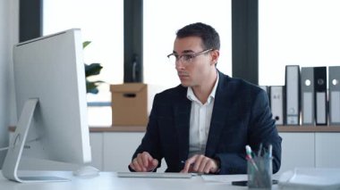 Modern bir girişimde dizüstü bilgisayarla çalışan konsantre ve zarif iş adamının videosu..