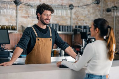 Pastanede kahve servisi yapan yakışıklı bir garsonun müşterisiyle konuşması.