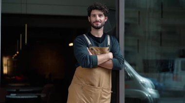 Yakışıklı garsonun kahve dükkanında akıllı telefon kullanırken mola verdiği bir video.