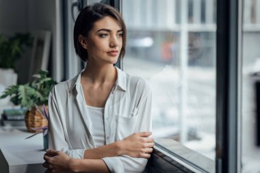 Evdeki pencerenin yanında duran güzel bir kadının portresi.