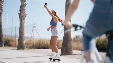 Güzel bir kadının kumsalda paten kayarken kulaklıkla müzik dinlediği video. 