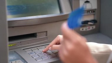 Güzel genç bir kadının bankamatikten kredi kartıyla para çekerken çekilmiş videosu.