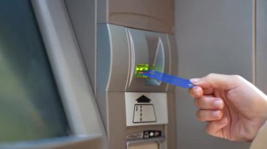 Güzel genç bir kadının bankamatikten kredi kartıyla para çekerken çekilmiş videosu.