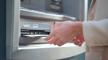 Güzel genç bir kadının bankamatikten kredi kartıyla para çekerken çekilmiş videosu.