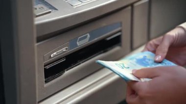 Güzel genç bir kadının bankamatikten kredi kartıyla para çekerken çekilmiş videosu.