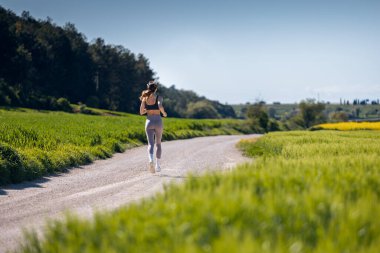 Kırsalda koşan bir kadının arka plan görüntüsü.