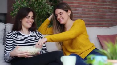 Evde kanepede patlamış mısır yiyen iki komik kadının videosu..