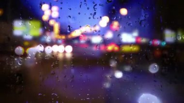 Şehirde fırtınada bir pencereden aşağı doğru yağmur yağıyor.