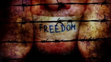 Man with freedom tape over mouth against barbwire
