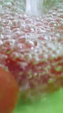 Yavaş çekim dikey videoda domateslere su sıçrıyor