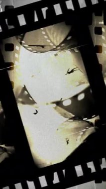 Çizikler ve ışık sızıntıları olan analog vinage film şeridi dikey video