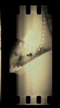 Çizikler ve ışık sızıntıları olan analog vinage film şeridi dikey video