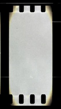 Çizikler ve ışık sızıntıları olan analog vinage film şeridi dikey video