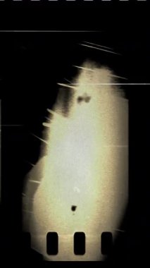 Çizikler ve ışık sızıntıları olan analog vinage film şeridi dikey video