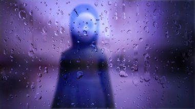 Geceleri yağmurlu pencerenin arkasındaki gizemli çarpık figür