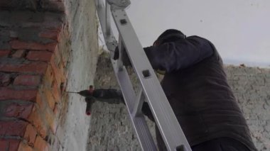 Tamirci, odanın tamiri sırasında duvarda bir delik açar. Odanın iyileştirilmesi ve restore edilmesi.