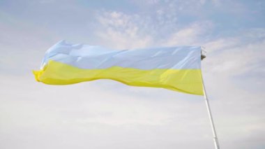 Ukrayna bayrağı gökyüzüne karşı rüzgarda dalgalanıyor.