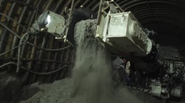 Bir maden makinesi maden kuyusundaki kayayı kesiyor.