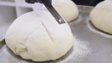 Ekmek ve ekmek hazırlamak için hamur işleriyle uğraşan fırıncı.