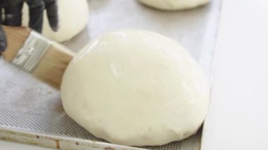 Ekmek ve ekmek hazırlamak için hamur işleriyle uğraşan fırıncı.