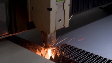 Metal plakadan plazma kesimi. Çelik bir levhadan çalışma malzemesi üretmek. Lazer kesici çalışıyor. Endüstriyel metal üretimi. Atölyede detayları anlatıyorum. Yavaşça kapat.