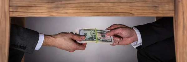 Hand Taking Bribe Under Table. Corruption Money