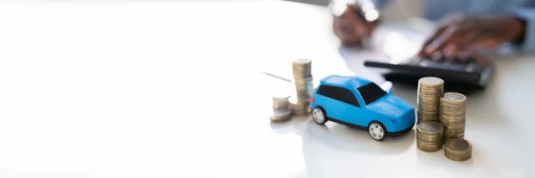ビジネスマンの前でおもちゃの車融資を計算 — ストック写真