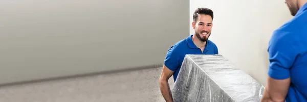 Professional Furniture Mover Carrying Heavy Sofa in House