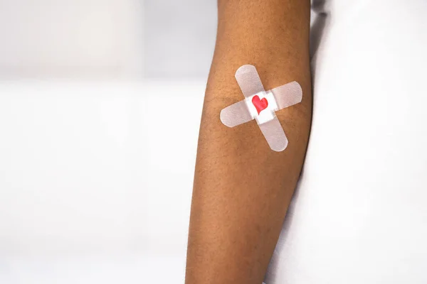 献血概念 有创可贴和爱心的非裔美国人捐助者 — 图库照片