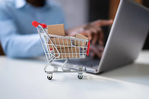 Miniature Shopping Cart Front Person Using Laptop — Stock Photo, Image
