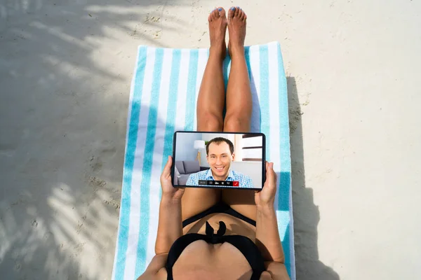 ビーチでのビデオ会議にタブレットを使用する若い女性 — ストック写真