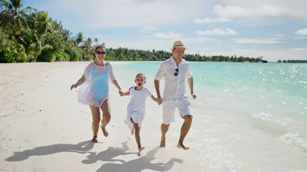 Aile sahilde birlikte koşuyor. Yaz Tatili