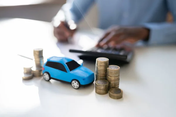ビジネスマンの前でおもちゃの車融資を計算 — ストック写真