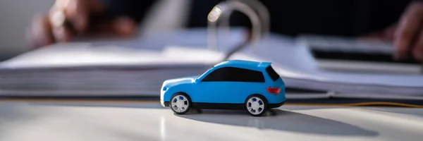 Niebieski Samochód Zabawki Przed Biznesmenem Obliczanie Pożyczki — Zdjęcie stockowe