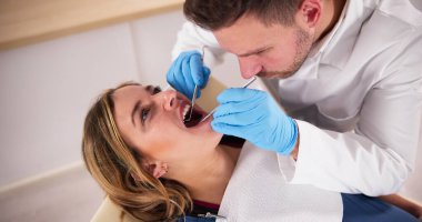 Klinikte yatan hamile kadının dişlerini tedavi eden diş hekimi.