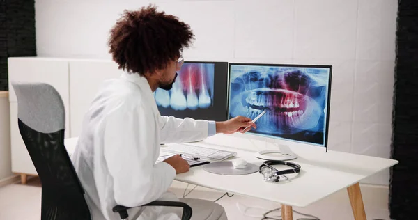 Dentist Looking At Teeth Xray Scan On Computer