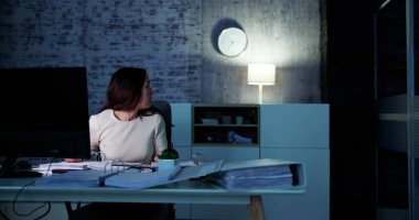 Businesswoman At Office Looking At Clock On Wall